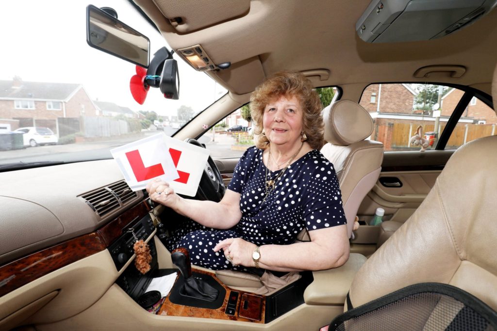 An older woman learning to drive
